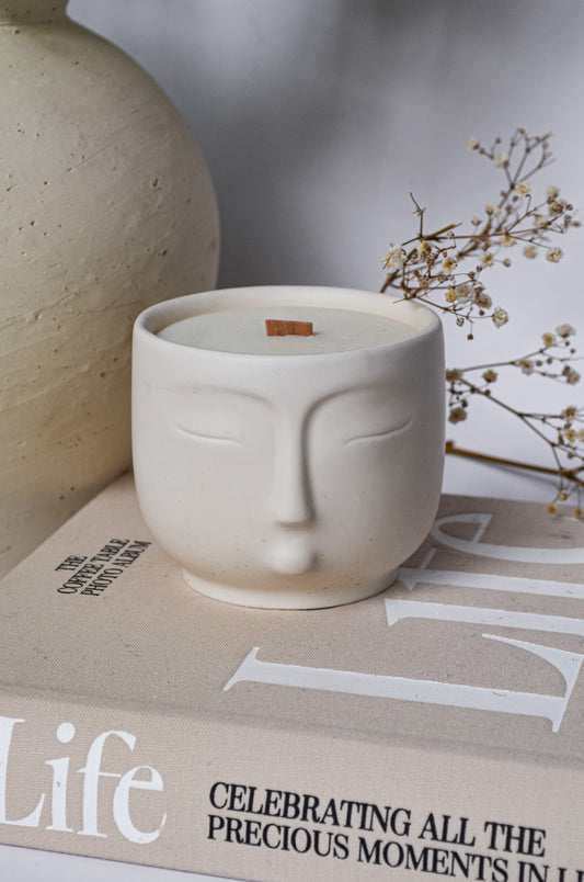 relaxing spa off white scented candle jar with face on it